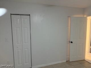 unfurnished bedroom featuring light tile patterned floors and a closet