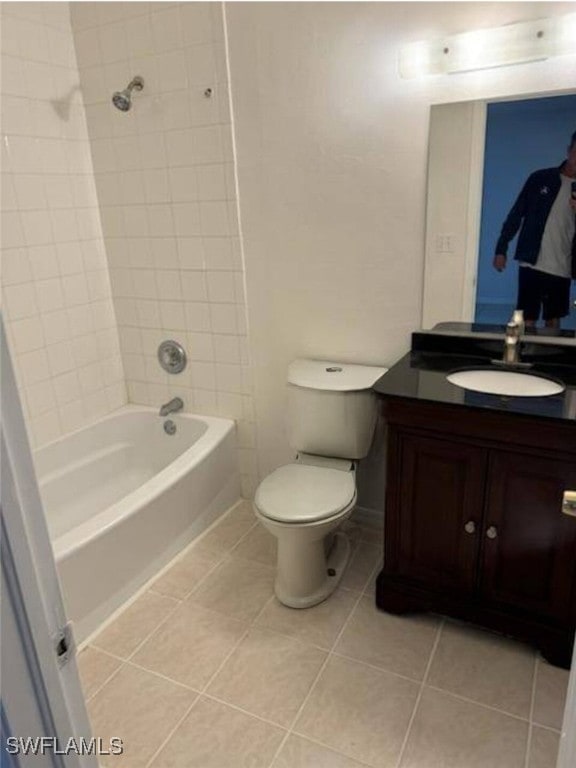 full bathroom featuring toilet, vanity, tiled shower / bath combo, and tile patterned floors