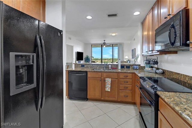 kitchen featuring stone countertops, ceiling fan, sink, light tile patterned floors, and black appliances