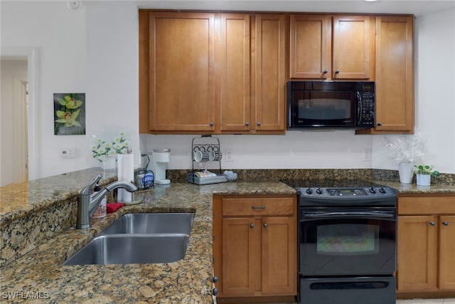 kitchen with sink, black appliances, and stone countertops