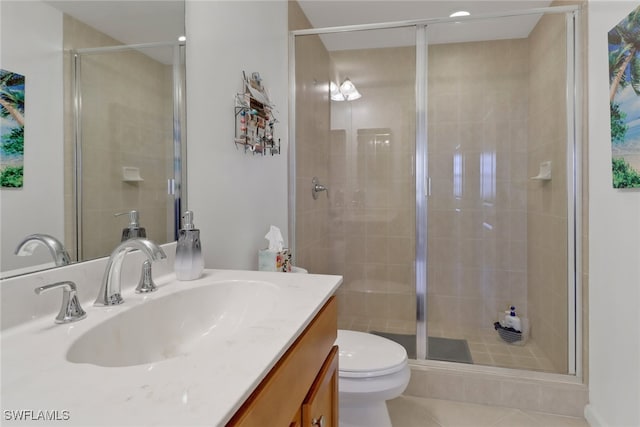 bathroom with tile patterned floors, toilet, walk in shower, and vanity