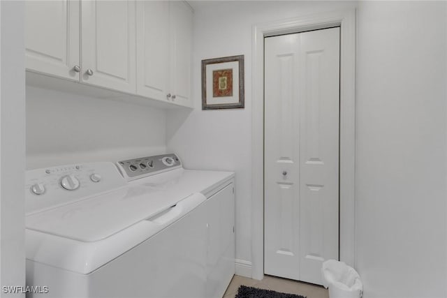 washroom featuring cabinets and washer and clothes dryer