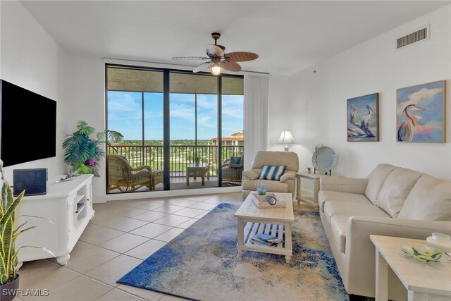 living room with floor to ceiling windows, light tile patterned floors, and ceiling fan