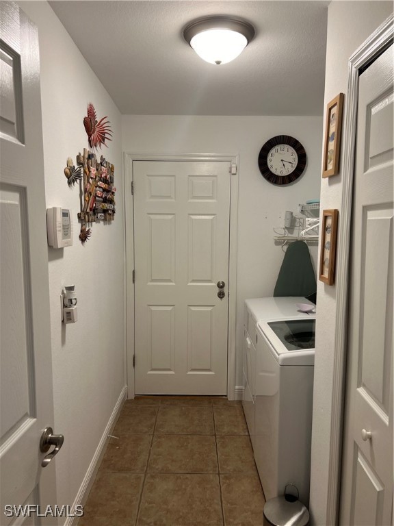 laundry room featuring independent washer and dryer and dark tile patterned floors