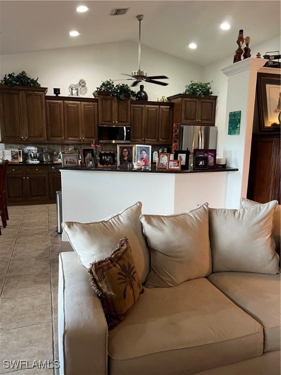 kitchen featuring appliances with stainless steel finishes, lofted ceiling, dark brown cabinets, and ceiling fan