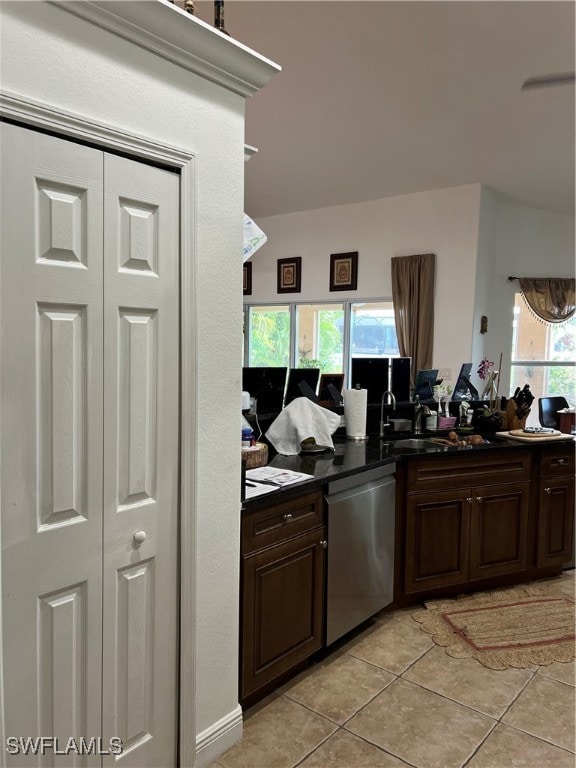 kitchen with dark brown cabinetry, dishwasher, and light tile patterned floors