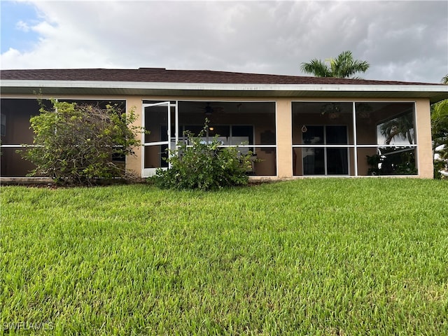 rear view of house featuring a lawn