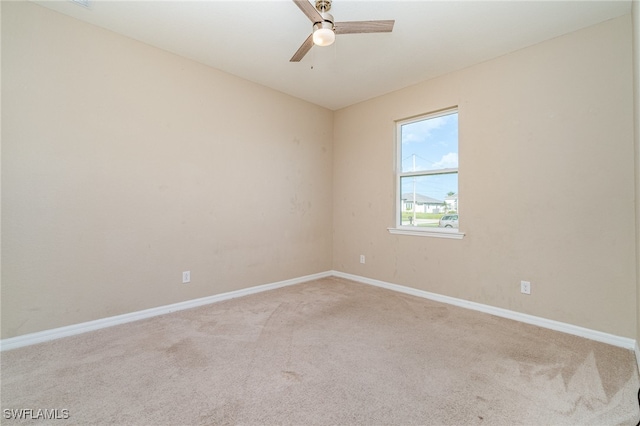 empty room featuring ceiling fan and light carpet