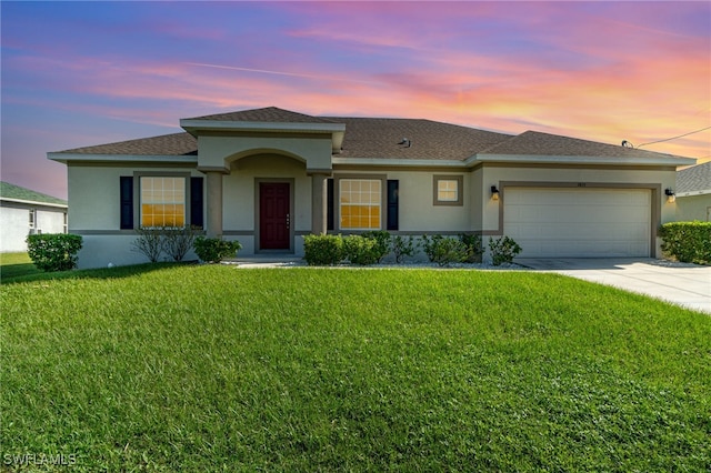 view of front of house with a garage and a yard