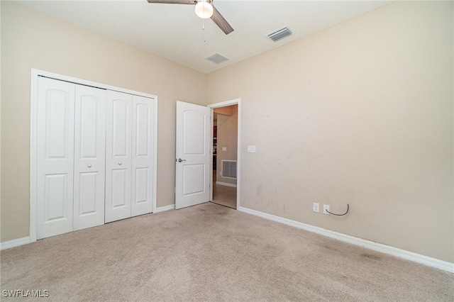 unfurnished bedroom featuring ceiling fan, a closet, and light carpet