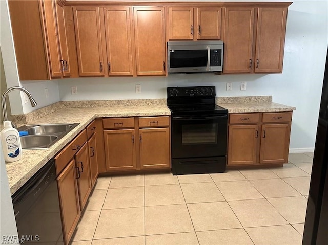 kitchen with black appliances, sink, and light tile patterned floors