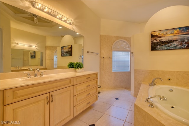 bathroom featuring tiled tub, vanity, tile patterned flooring, and ceiling fan