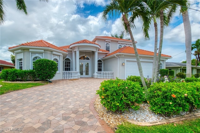 mediterranean / spanish-style house featuring a garage and french doors