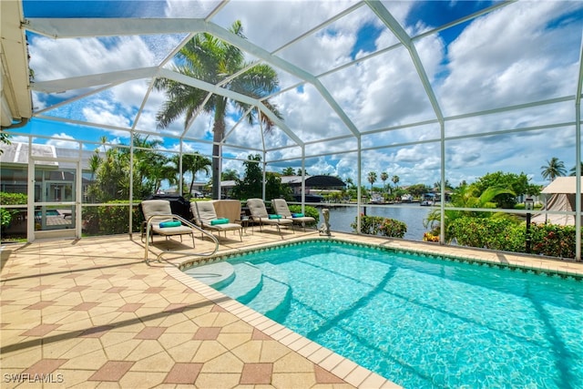 view of pool with a water view, a patio, and glass enclosure