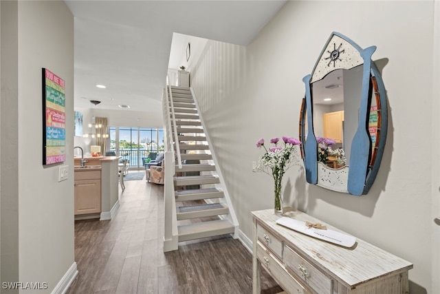 stairway with hardwood / wood-style flooring and sink