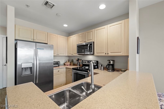 kitchen featuring kitchen peninsula, stainless steel appliances, and sink