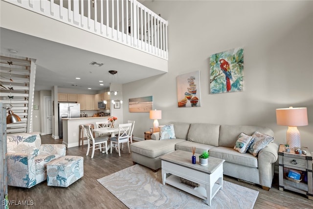 living room featuring a high ceiling and wood-type flooring