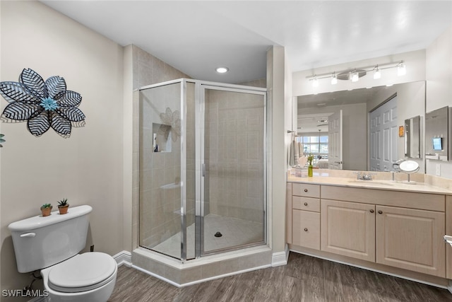 bathroom featuring vanity, hardwood / wood-style floors, toilet, and an enclosed shower