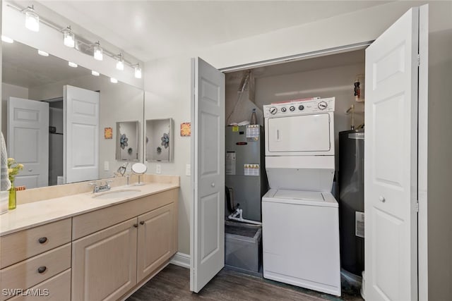 bathroom featuring vanity, stacked washing maching and dryer, wood-type flooring, and water heater