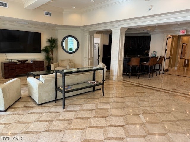 living room featuring decorative columns, beamed ceiling, ornamental molding, and a high ceiling