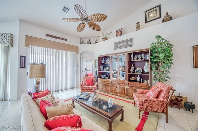 living room featuring ceiling fan, vaulted ceiling, and light tile patterned floors