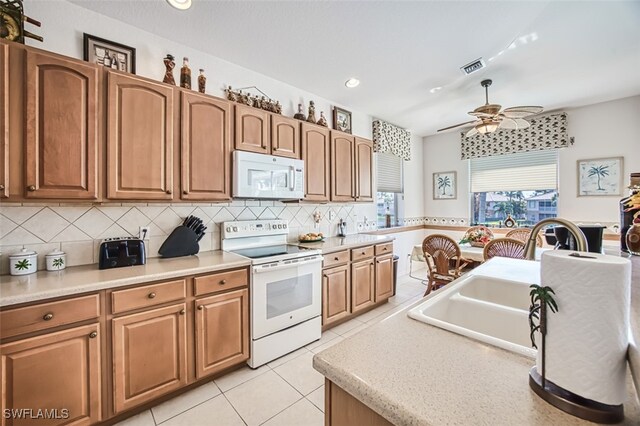 kitchen featuring white appliances, tasteful backsplash, sink, ceiling fan, and light tile patterned floors