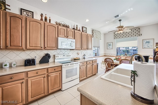 kitchen with visible vents, backsplash, light countertops, light tile patterned flooring, and white appliances