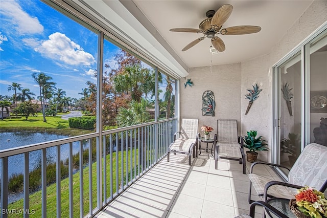 sunroom / solarium with a water view and ceiling fan