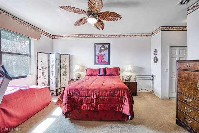 carpeted bedroom with visible vents, a ceiling fan, and baseboards