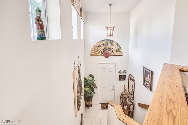 entryway featuring light tile patterned flooring and a towering ceiling