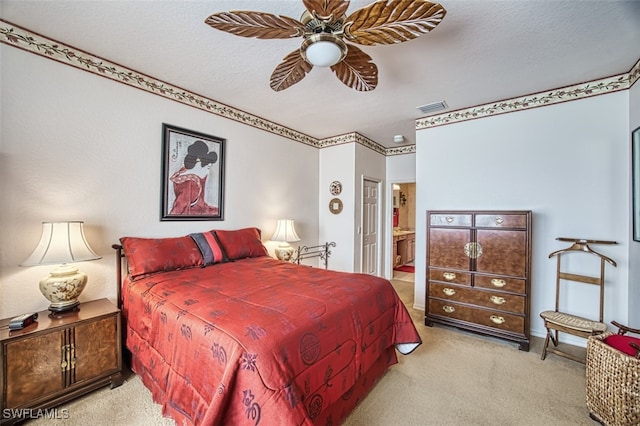 carpeted bedroom with ensuite bath, a textured ceiling, and ceiling fan