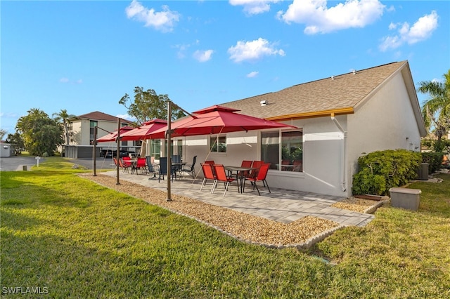 back of property with central AC, a yard, and a patio