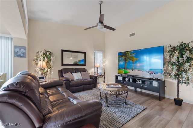 living room featuring high vaulted ceiling, light hardwood / wood-style flooring, and ceiling fan