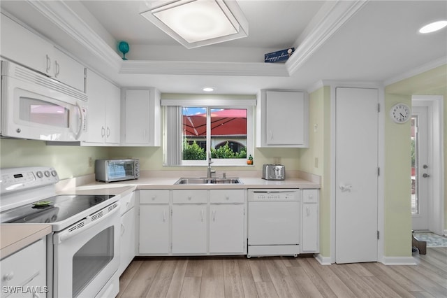 kitchen with white cabinets, white appliances, light hardwood / wood-style floors, and sink