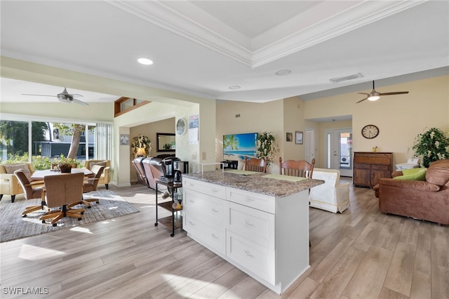 kitchen featuring light hardwood / wood-style floors, white cabinetry, crown molding, and light stone counters