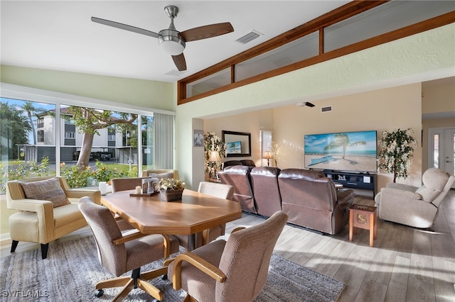 dining room with ceiling fan, hardwood / wood-style floors, and lofted ceiling