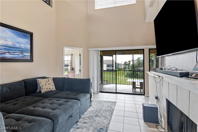 tiled living room featuring a high ceiling and a tile fireplace