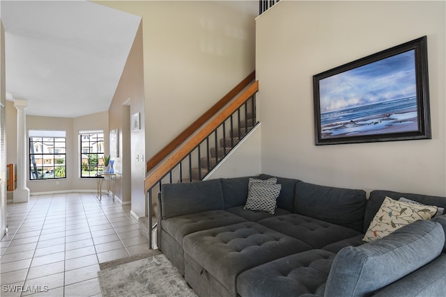 tiled living room with high vaulted ceiling and decorative columns