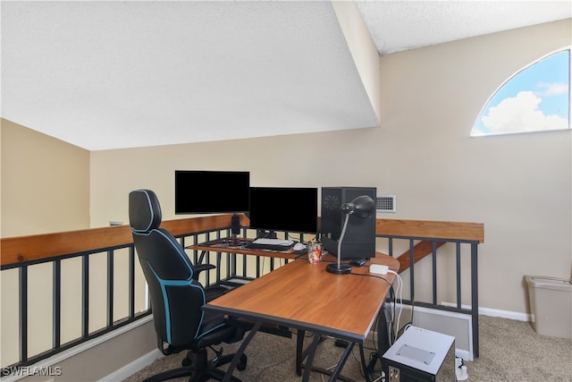 home office featuring carpet floors, vaulted ceiling, and a textured ceiling