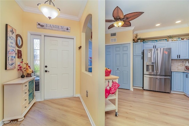 foyer with light wood-type flooring, ceiling fan, and crown molding