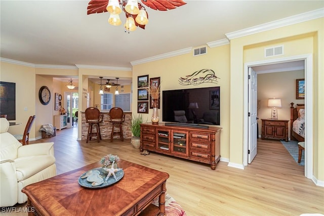 living room featuring ornamental molding and light hardwood / wood-style flooring