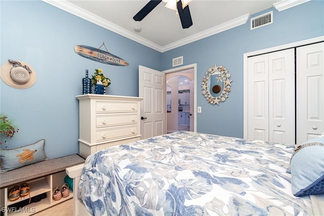 bedroom with ceiling fan, crown molding, and a closet