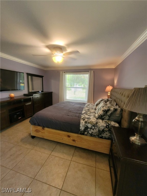 bedroom with light tile patterned floors, crown molding, and ceiling fan