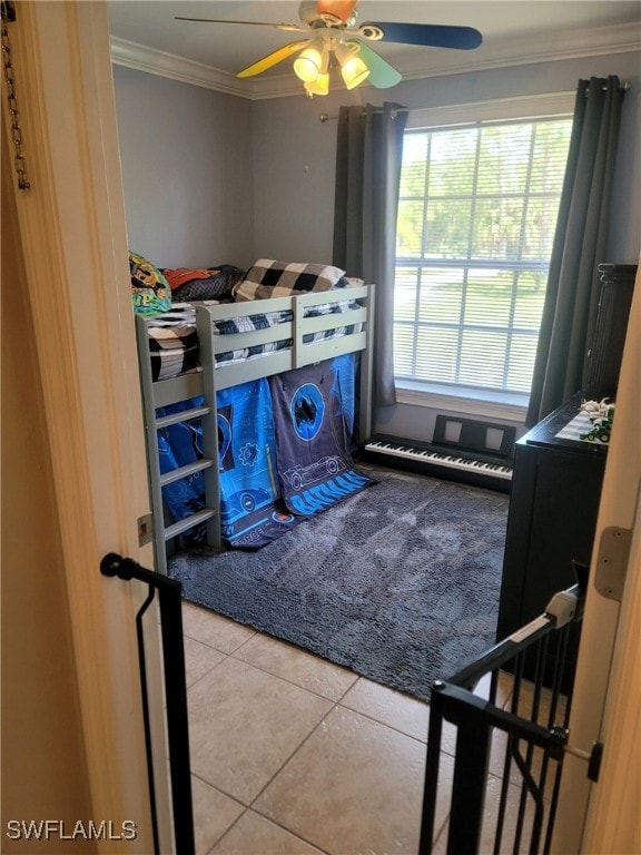 tiled bedroom featuring crown molding and ceiling fan