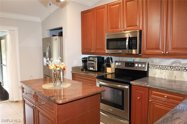 kitchen featuring appliances with stainless steel finishes, backsplash, dark stone counters, light tile patterned floors, and crown molding