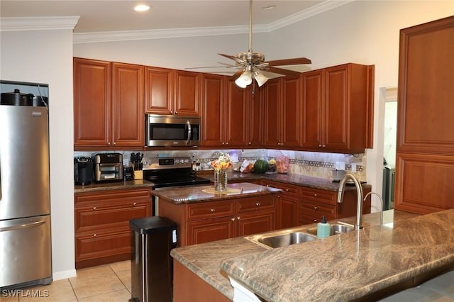 kitchen with sink, light tile patterned floors, a kitchen island with sink, stainless steel appliances, and dark stone counters