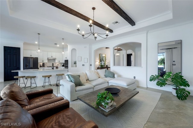 living room featuring beam ceiling, sink, a chandelier, and crown molding