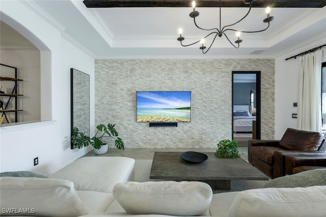 living room with ornamental molding, a tray ceiling, and a chandelier