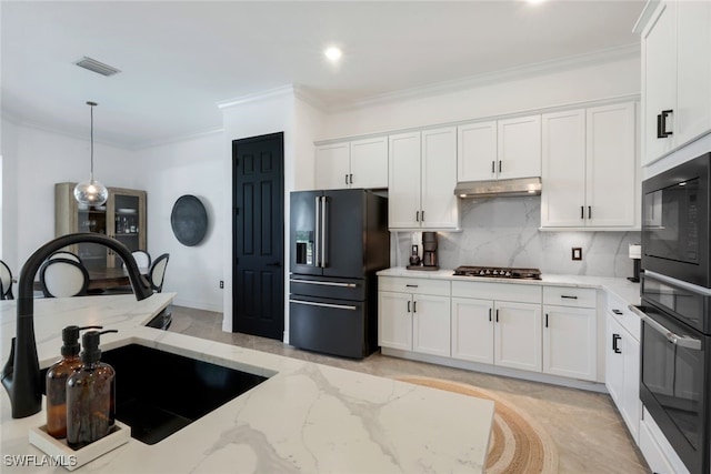 kitchen featuring white cabinets, high quality fridge, light stone counters, and decorative light fixtures