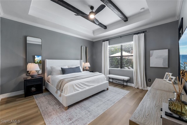 bedroom featuring light hardwood / wood-style floors, a raised ceiling, ornamental molding, and ceiling fan